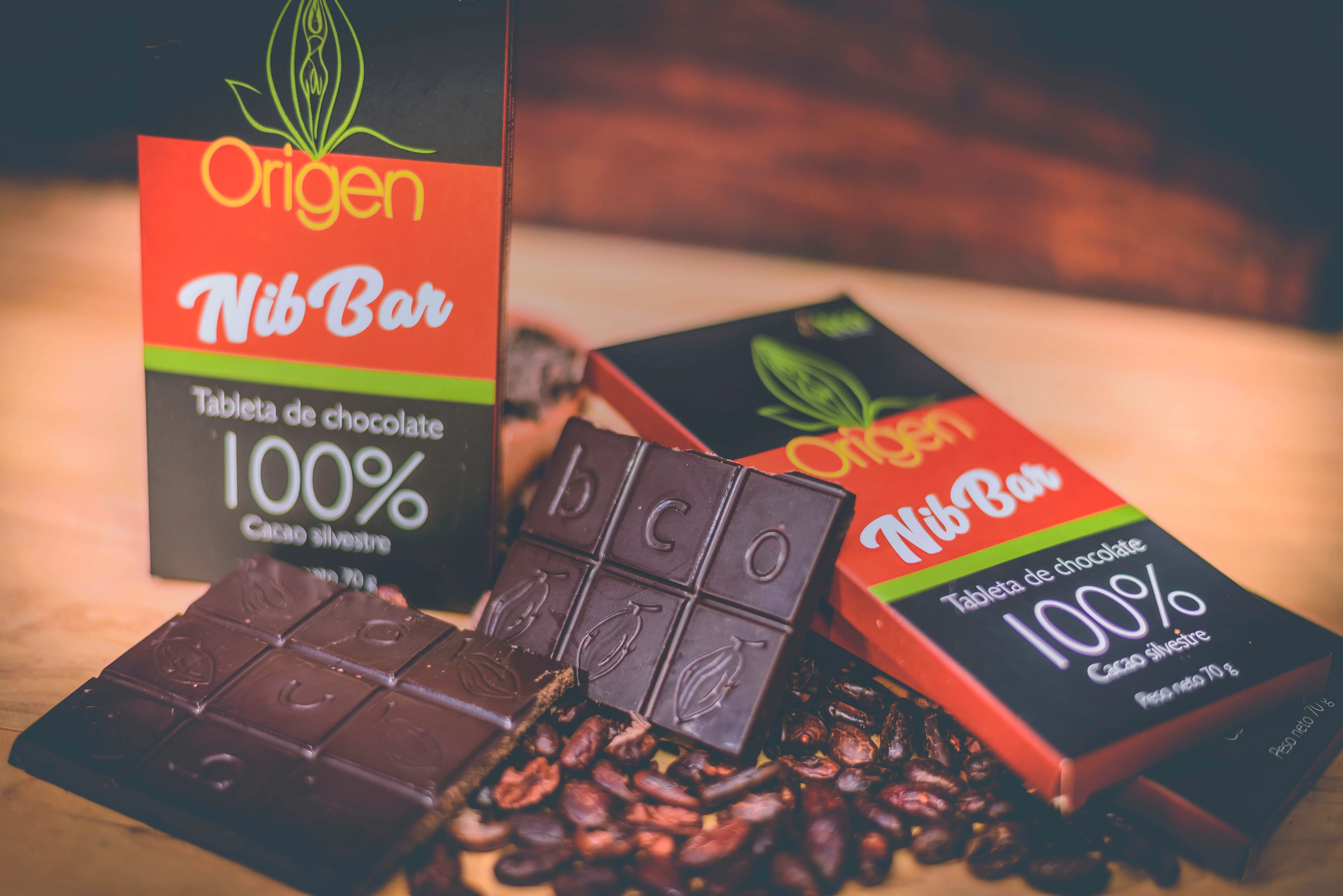 Fotografia de producto de chocolate con envoltorios, graños y luz calida.